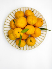Orange fruit with green leaves on the white background. Home gardening. Mandarine oranges. Tangerine oranges. Orange color. Fresh orange juice.