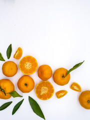 Orange fruit with green leaves on the white background. Home gardening. Mandarine oranges. Tangerine oranges. Orange color. Fresh orange juice.
