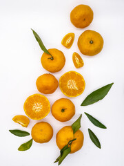 Orange fruit with green leaves on the white background. Home gardening. Mandarine oranges. Tangerine oranges. Orange color. Fresh orange juice.