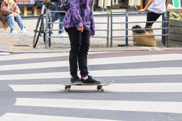 young person with a skateboard on a city street