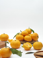 Orange fruit with green leaves on the white background. Home gardening. Mandarine oranges. Tangerine oranges. Orange color. Fresh orange juice.