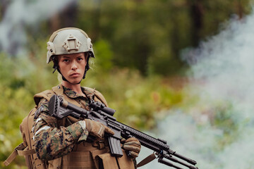 Fototapeta premium Woman soldier ready for battle wearing protective military gear and weapon