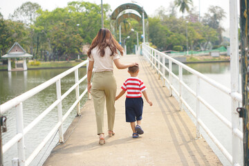 Mother takes baby for a walk in the park holiday