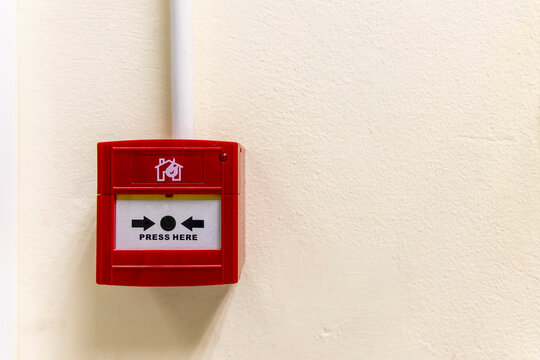 A red fire alarm button inside hospital or factory industry zone.Fire alarm use for emergency warning purpose.Fire alarm button on wall with blur background.Nobody is in picture with space.