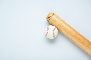 Wooden baseball bat and ball on light grey background, flat lay. Space for text