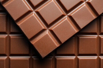 Delicious milk chocolate bars as background, top view