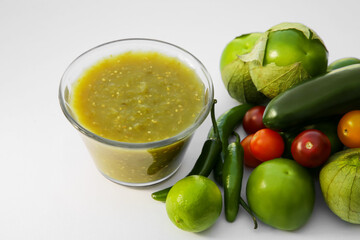 Bowl with delicious salsa sauce and ingredients on white background, closeup