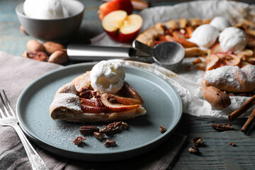 Delicious apple galette with ice cream and pecans on wooden table