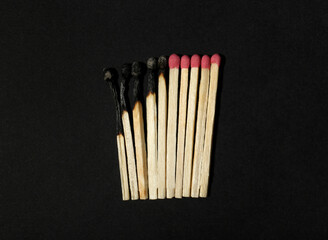 Burnt and whole matches on black background, flat lay. Stop destruction concept