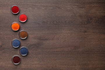 Many different food coloring on wooden table, flat lay. Space for text