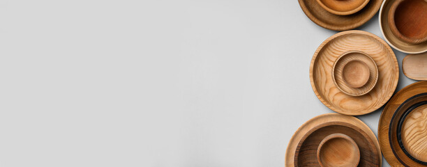 Set of different wooden dishes on light grey background, flat lay with space for text. Banner design