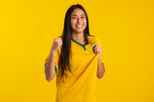 Brazilian soccer fan in studio photo with yellow backgroun