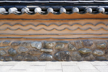 Stone pattern wall and tile roof of Korean traditional house.  oriental stone wall background.