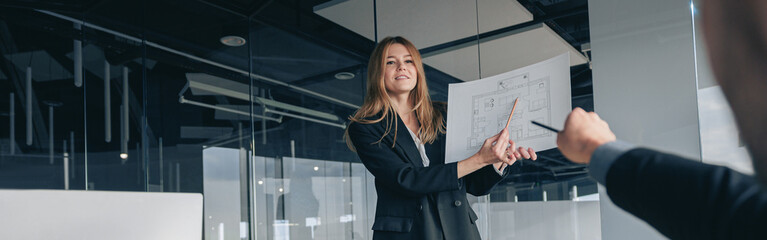 Attractive business woman during meeting showing her project to colleagues