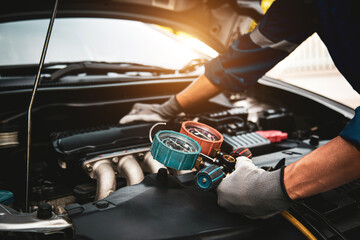 Car care maintenance and service, Hand technician auto mechanic using measuring manifold gauge check refrigerant and filling car air conditioner to fix repairing heat conditioning system. - obrazy, fototapety, plakaty