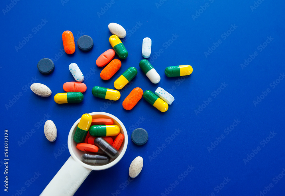 Wall mural Assorted pharmaceutical medicine pills, tablets and capsules over blue background