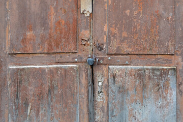 Old wooden door with peeling paint. Cracked, rotten, shabby wooden texture.