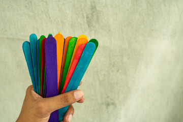 A bunch of Colourful Ice cream sticks held in hand, International colour day concept Selective focus