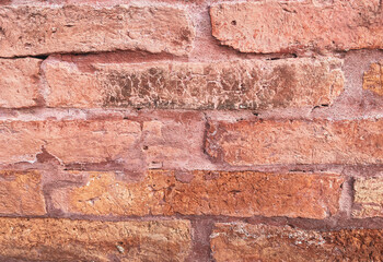 A red brick wall, The bricks are uniform in size and shape, arranged in a traditional brick bond pattern  rows offset from each other. The white color of the bricks gives the wall a modern look