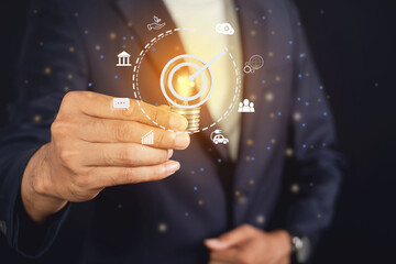 Businessman holding light bulb with globe icons. environmental conservation and modernization of technology and natural resources to reduce pollution and carbon emissions.