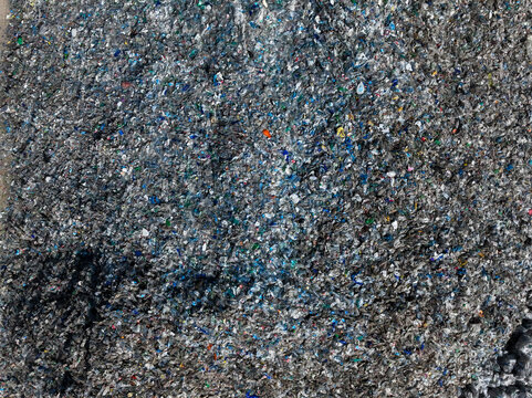 Plastic bottles and Trash Soda cans recycling piles in a local facility, Top down view