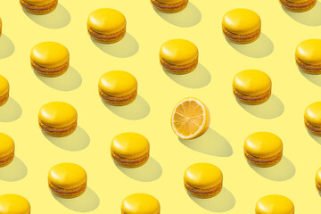 Lemon yellow macarons pattern on yellow background isolated with hard shadows