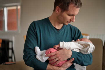 Portrait of man holding newborn baby girl
