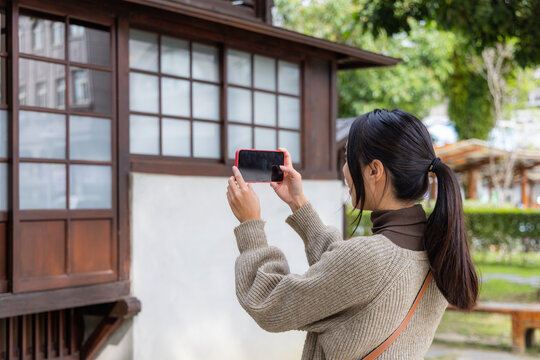 Woman use mobile phone to take photo in Japanese house
