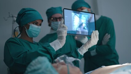 Professional medical team talking and discuss x-ray of patient with lung pneumonia caused by infection at radiology department in hospital. Covid-19 xray test, covid worldwide virus epidemic - Powered by Adobe