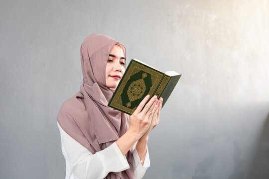 Young muslim woman reading Quran in the mosque and sunlight falling from the window