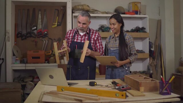 4K Carpenter couples are talking to customers online or over the phone. They're presenting about woodworking and delighted after closing the big lot sale at Wood Factory in wood craftsmanship concept.