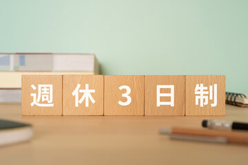 週休3日制と書かれたブロックが置かれたデスク