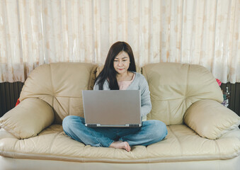 Asian young woman's resting and using credit card for online shopping and browsing internet with laptop. Entrepreneur or Businesswoman working from home. Online concept.