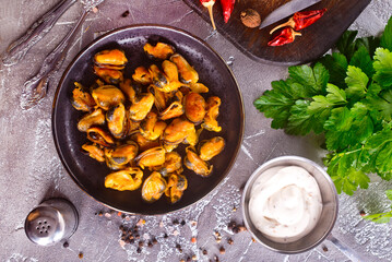 Fried mussels with onions on skewers with spice and parsley