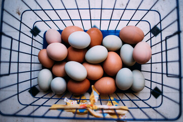 Overhead view of eggs in metal basket on table