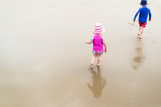 High angle view of siblings walking at beach