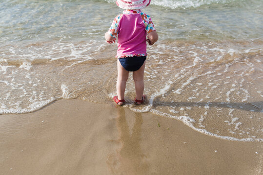 Rear view of girl standing at beach