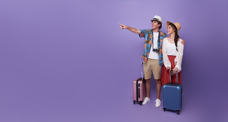 Happy couple tourist hand pointing to copy space with baggage going to travel on holidays isolated...