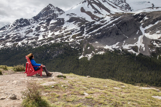 Hiker looking at view while resting on chair against mountains