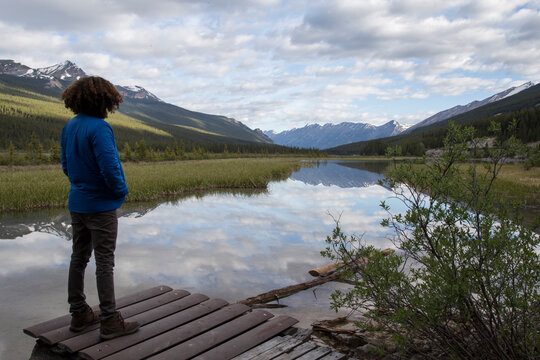 Man looking at view while standing on wood against cloudy sky