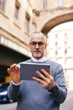 Man using tablet computer while standing in city