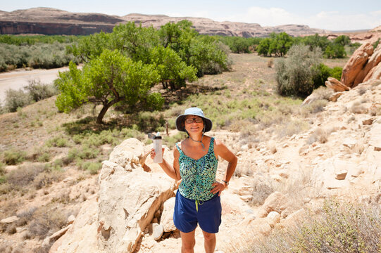 High angle portrait of confident woman with hand on hip standing on rocks