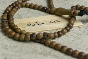 Islamic quotes. Eid Mubarak words written on wooden stick.