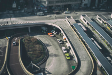 High angle tilt-shift image of vehicles on road in city
