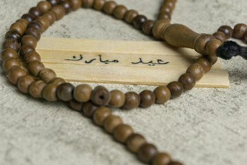 Islamic quotes. Eid Mubarak words written on wooden stick.