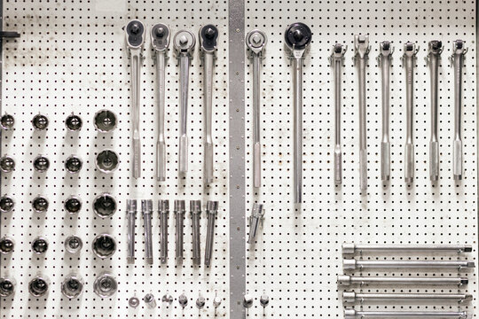 Close-up of work tools hanging on pegboard