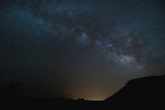 Silhouette landscape against star field at night