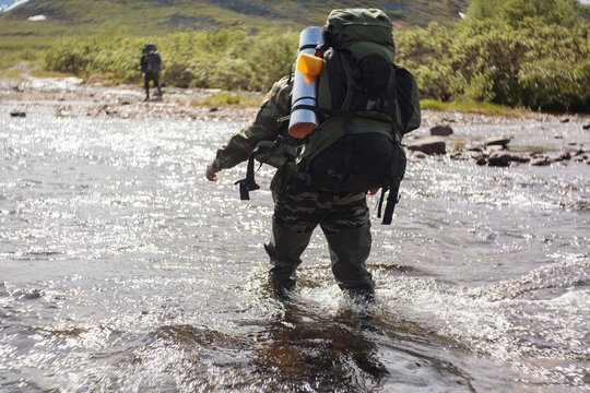 Hiker walking in river