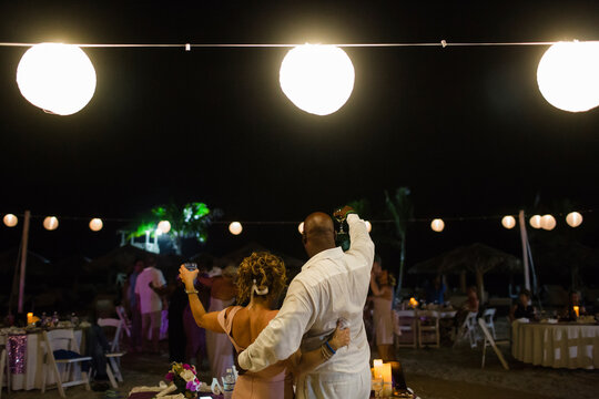 Rear view of couple raising toast at party