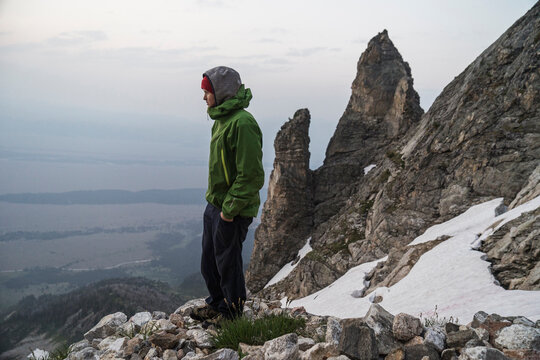 Side view of man with hands in pockets standing on mountain during winter